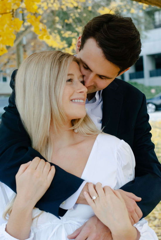 An engaged couple embracing with photo taken by Kent Collective Photography