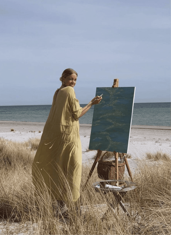 An artist painting at the beach